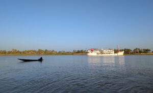 bateau de croisière Bou el Mogdad sur le fleuve Sénégal en arrière plan et une pirogue au premier plan